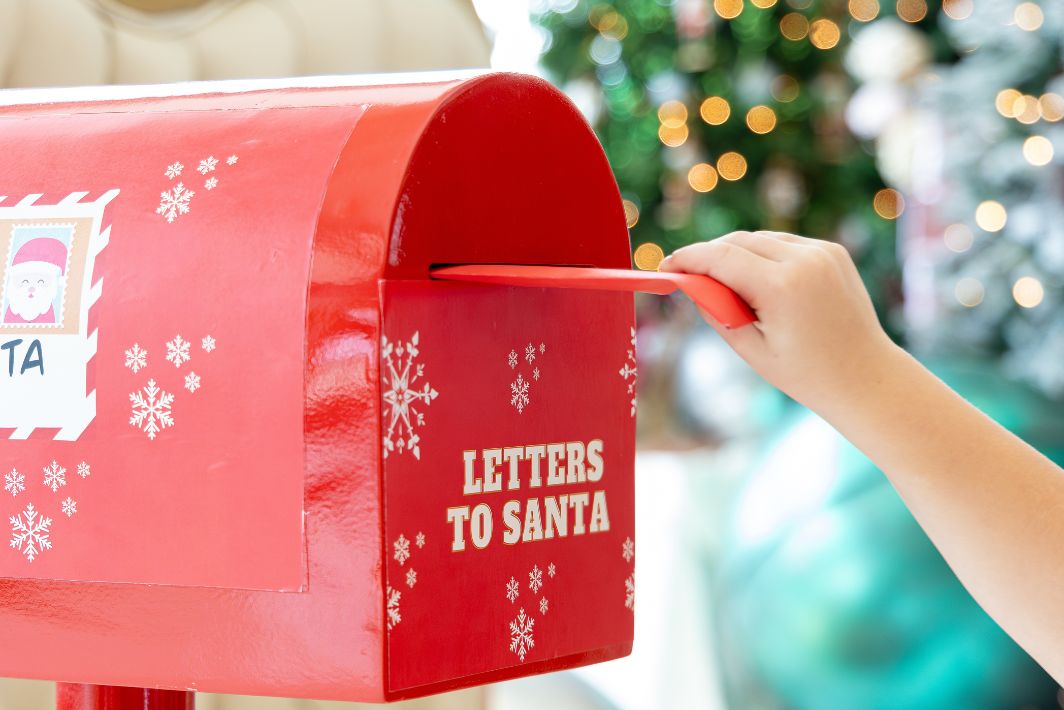 a hand holding a letter in a mailbox